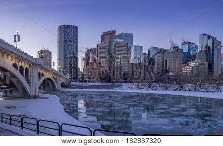 CALGARY, CANADA - DEC 17: Calgary's skyline at sunrise on a cold winter day on December 17, 2016 in Calgary, Alberta. Calgary is home to many oil companies. The Bow River is visible.