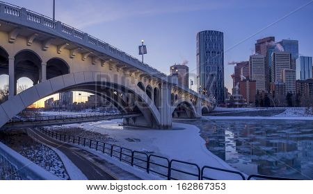 CALGARY, CANADA - DEC 17: Calgary's skyline at sunrise on a cold winter day on December 17, 2016 in Calgary, Alberta. Calgary is home to many oil companies. The Bow River is visible.