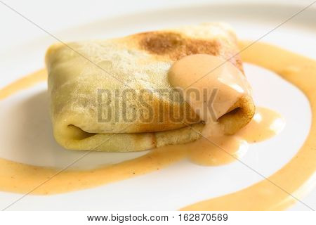 Hungarian Hortobagyi Palacsinta or Crepe a la Hortobagy a savory thin pancake filled with minced meat and served with a paprika and sour cream sauce based on the sauce of the meat photographed with natural light (Selective Focus Focus on the front of the