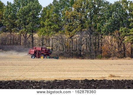 Harvester is working in the field during harvest time.