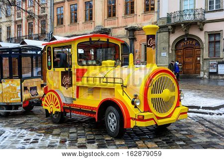 Ukraine Lviv - December 15 2016: Sightseeing road train in the Rynok Square next to Lviv city council expects tourists for a sightseeing tour of the city of Lviv.