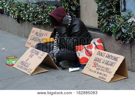NEW YORK - DECEMBER 15, 2016: Homeless man in front of Sacks Fifth Avenue store in Midtown Manhattan