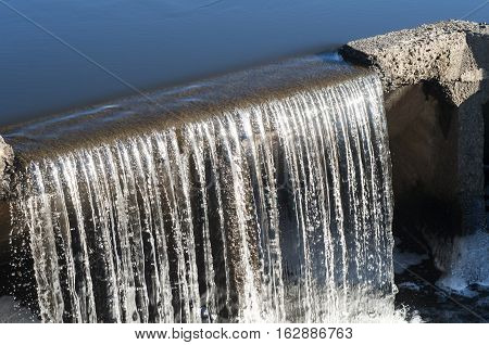 Pond overflow in action closeup in sunny day