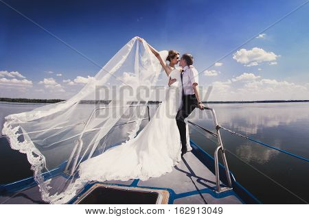 Just Married Couple On Yacht. Happy Bride And Groom On Their Wedding Day