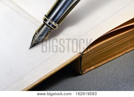 Open blank page of a book and the nib of a fountain pen
