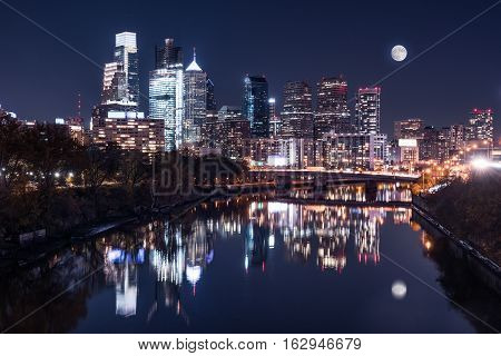 Moon over the Philadelphia night skyline reflects on the Schuylkill river