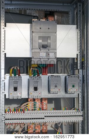 Connecting cables with cable lugs to circuit breakers in the electrical control panel on the artboard. Alignment of the components to ensure safety and reliability.
