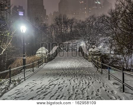 Gapstow Bridge is one of the icons of Central Park Manhattan in New York City during snow storm at night