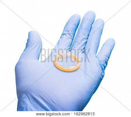 Hand in glove holding a condom. Doctor and contraceptives. White isolated