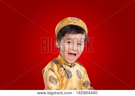 Portrait of a happy smiling handsome Asian baby boy on traditional festival costume. Cute little Vietnamese boy in ao dai dress smiling.