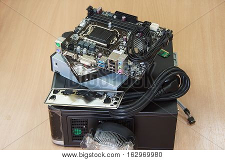 Accessories for assembly of personal computer on wooden table.