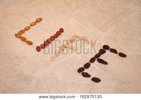 Text of nuts and raisins on marble table.