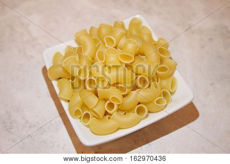 Pasta in square plate isolated on your desktop.