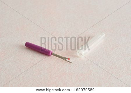A purple stitch unpicker isolated on a white background