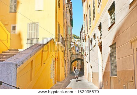 MENTON FRANCE - FEBRUARY 22 2012: The tall mediterranean houses painted in bright colors decorate the maze of narrow streets of old town on February 22 in Menton.