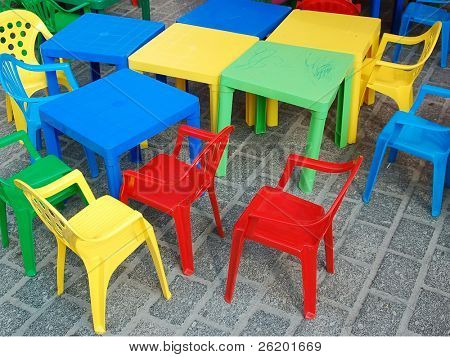 Campo de jogos com mesas e cadeiras de criança de plástico colorido