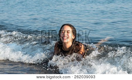 Teen Laying On Her Stomach At Beach Laughing