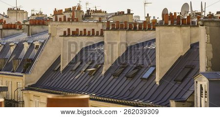 The Roofs Of Paris And Its Chimneys Under A Clouds Sky