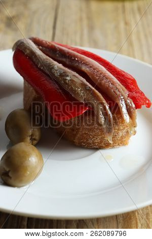 Spanish Tapa - Slice Of Bread With Roasted Red Pepper, Anchovy And Olive Oil, Closeup