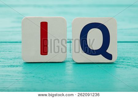 Intelligence Quotient. Word Iq On Blue Wooden Background. Copy Space. Mock Up. School And Education 