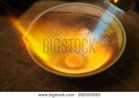 Proccess of illegaly melting of stolen gold pieces in ceramic bowl