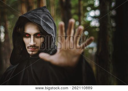 The Black Monk Pointing His Finger In The Woods