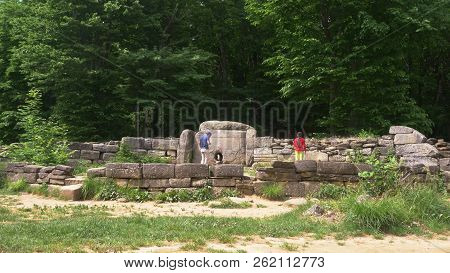 Dolmen In The Forest. Tourists Explore The Ancient Dolmens