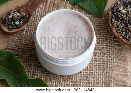A Jar Of Homemade Comfrey Ointment With Fresh Symphytum Officinale Leaves And Dried Root