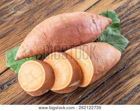 Sweet potatoes on the old wooden table.