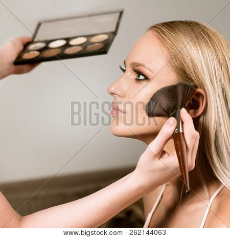 makeup styl?st apply?ng makeup on the model closeup beauty face makeup brushes