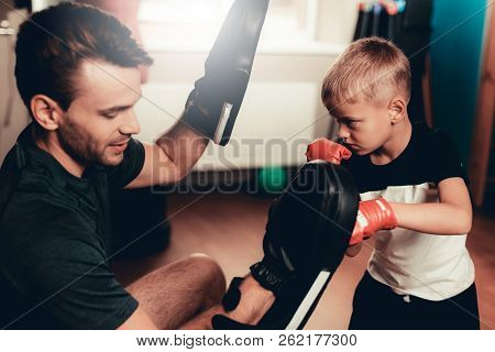 Father And Son Boxing Exercises Training In Gym. Parenthood Relationship. Sporty Family Concept. Act