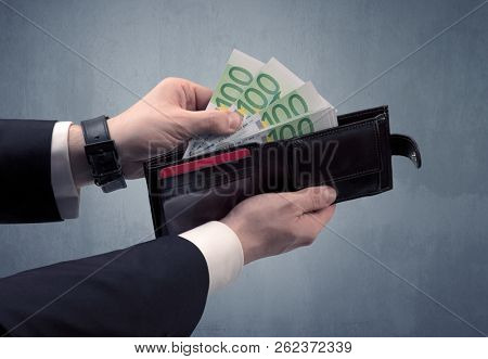 Businessman's hand in suit takes out eruo from his wallet