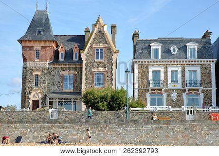 Saint Malo, France - August 27, 2018: Colorful House Facades Along Sillon Beach With People Walking 