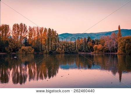 Teal And Orange Mood Of Autumn Colors And Reflection On The Puigcerda's Pond Water