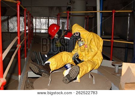 Surgutskaya GRES-2, Surgut, Russia, 24.07.2012. Rescue exercises at a chemical plant to rescue the victim. Two figures in protective clothing and gas masks depicting victims of chemical poisoning.