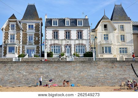 Saint Malo, France - August 27, 2018: Colorful House Facades Along Sillon Beach With People Walking 