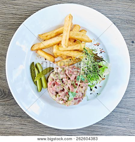Meat Tartar With French Fries And Vegetable Salad.