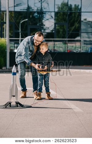 Happy Father And Son Launching Model Rocket Outdoor