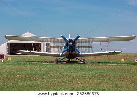 The Old Plane, Agricultural Aeroplane Costs In The Field In A Green Grass.
