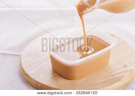 Sweetened Condensed Milk On Wooden Background, Plate.