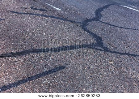 Damaged Road, Cracked Asphalt Sword With Potholes And Spots, Ukraine. Very Bad Asphalt Road With Lar