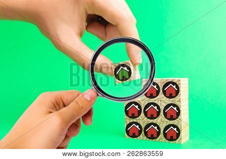 The Businessman's Hand And Wooden Cubes With Houses. Investment In Real Estate. Buildin, Sale, Rent,