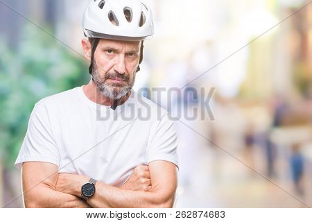 Middle age senior hoary cyclist man wearing bike safety helment isolated background skeptic and nervous, disapproving expression on face with crossed arms. Negative person.