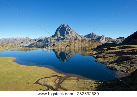 Midi Dossau Peak reflected in Gentau lake. Ossau Valley, Pyrenees National Park, Pyrenees, France.