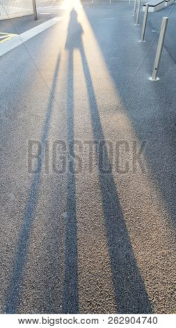 Black Long Morning Shadow Of People On The Streetside