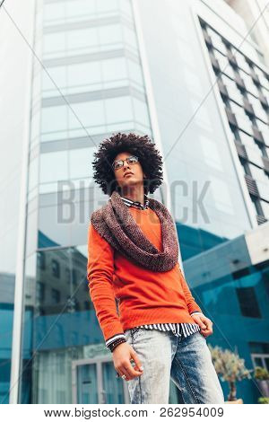Young Fashionable Dressed Curly Black African American With Glasses Walks Through The Streets Agains