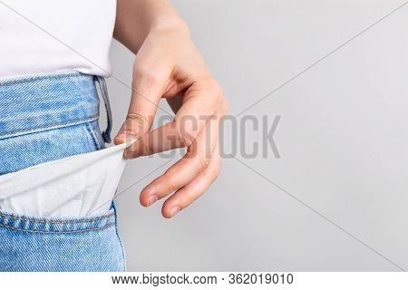 Woman Showing Empty Pockets With No Money. Bancruptcy Concept.