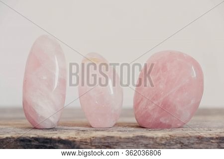 Polished Crystals Rose Quartz Gemstone On A Wooden Table. Copy, Empty Space For Text