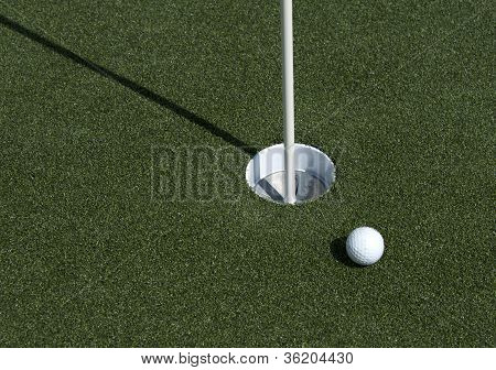 Golf Ball And Hole On A Field