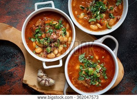 Bean Soup With Meat And Vegetables Served On A Rustic Board With Garlic. Traditional Balkan Soup Or 